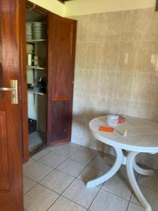 een kamer met een tafel en een keuken met een plank bij AEROPARK RESIDENCIAL2 in Maputo