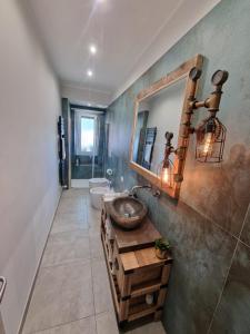 baño con lavabo y espejo en la pared en Studi011 slow travel, en Turín