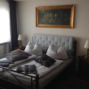 1 cama con 2 almohadas y una foto en la pared en Landpension Villa Dominikus, en Mömbris