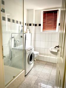 a bathroom with a washing machine in a shower at stayinhostel in Hamburg