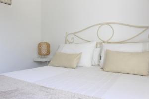 ein Schlafzimmer mit einem weißen Bett mit Kissen in der Unterkunft Casa Rural La Senda de Aroche in Aracena