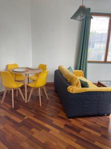 sala de estar con sofá, mesa y sillas en Appartement 35 m2 1er étage 200 m de la mer, en Luc-sur-Mer