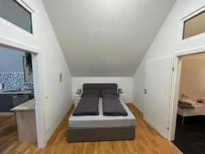 een kleine slaapkamer met een bed op zolder bij Paky Appartements 00323 in Bruck an der Leitha