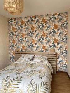sypialnia z łóżkiem i tapetą w kwiaty w obiekcie Appartement 35 m2 1er étage 200 m de la mer w mieście Luc-sur-Mer