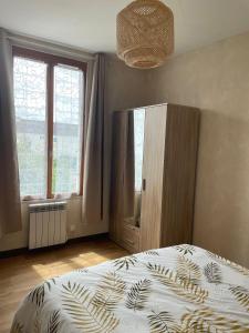 1 dormitorio con 1 cama y armario con ventanas en Appartement 35 m2 1er étage 200 m de la mer, en Luc-sur-Mer