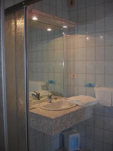 un bagno con lavandino e specchio di Hotel Restaurant Le Capricorne a Pouldreuzic Altre 69 foto