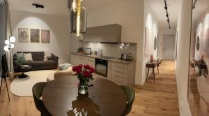 eine Küche und ein Wohnzimmer mit einem Tisch im Zimmer in der Unterkunft My Marina Apartment mit Pool und Sauna am See in Bad Saarow