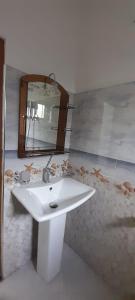 La salle de bains est pourvue d'un lavabo blanc et d'un miroir. dans l'établissement Travelers Halt, à Talalla South