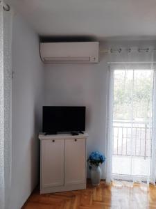 een woonkamer met een tv op een kast en een raam bij Apartment Marko in Kaštela