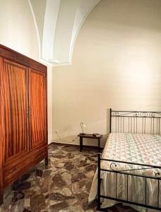 una camera con letto e armadio in legno di Maison Li Signuri a Maglie