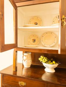 un armadio con una ciotola di uva e piatti di Maison Li Signuri a Maglie