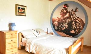 1 dormitorio con una pintura de motocicleta en la pared en Chambres chez l'habitant - Chez Nico & Belen 