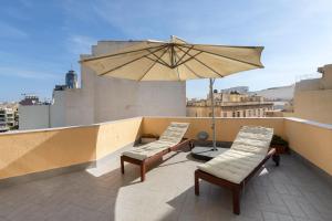 patio con due sedie e ombrellone sul tetto di Lapsi Apartments - Traditional Maltese Style near the Promenade a San Giuliano