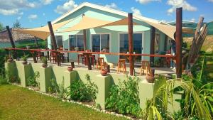 a house with tables and umbrellas in front of it at Shaquila Lodge in Fernão Veloso