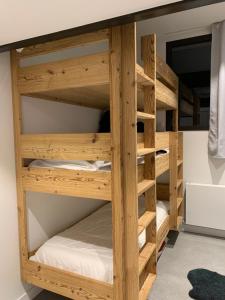 フレーヌにあるFlaine Forum H1 Cassiopée Mezzanine & Terrasseの木製の二段ベッドが備わる客室です。