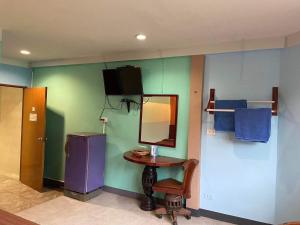 โรงแรมมวกเหล็กเกสท์อินท์ : غرفة مع طاولة صغيرة ومرآة وثلاجة