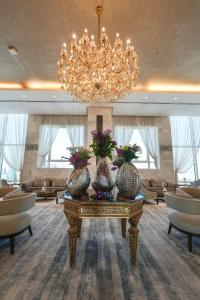 a large lobby with a chandelier and vases on a table at Grand Majestic Hotel Kuwait in Kuwait
