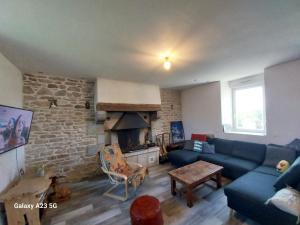 salon z niebieską kanapą i kominkiem w obiekcie Manoir de kerozet - Chambres chez l'habitant - 3 chiens w mieście Plouider