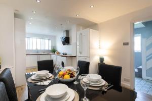 a kitchen with a table with a bowl of fruit on it at *Contractors, Holidays, Races, 25% off long stays* in Cheltenham