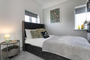 1 dormitorio con 1 cama y mesa auxiliar en *Contractors, Holidays, Races, 25% off long stays* en Cheltenham