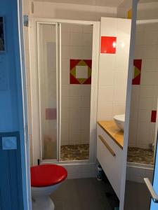 W łazience znajduje się czerwona toaleta i prysznic. w obiekcie Studio Bayonne avec balcon w Bajonnie