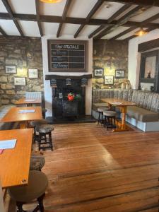 a restaurant with wooden tables and chairs and a fireplace at The hermitage inn in Warkworth