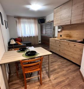une cuisine avec une table et des chaises ainsi qu'une cuisine avec une cuisinière dans l'établissement Bianca's apartments, à Breuil-Cervinia