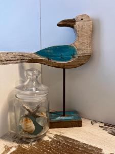un barattolo di vetro con un uccello di legno su una mensola di Hotel Acquamarina a Portoferraio