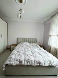een wit bed in een witte slaapkamer met een raam bij Guest House - Happy Apart in city center Tirana in Tirana