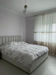 een bed in een witte slaapkamer met een raam bij Guest House - Happy Apart in city center Tirana in Tirana