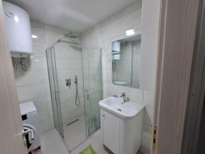 een witte badkamer met een douche en een wastafel bij Guest House - Happy Apart in city center Tirana in Tirana