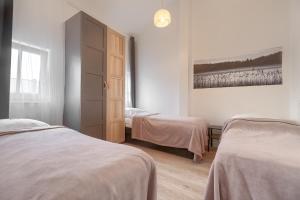 a bedroom with two beds and a painting on the wall at Kamienica Centrum Apartament 18 in Szczecin