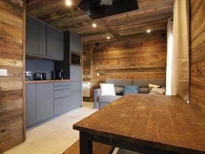 cocina y sala de estar con pared de madera en Appartement Huez, 3 pièces, 6 personnes - FR-1-405-8, en L'Alpe-d'Huez