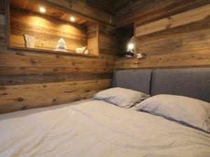 ラルプ・デュエズにあるAppartement Huez, 3 pièces, 6 personnes - FR-1-405-8の木製の壁のベッドルーム1室、ベッド1台(枕2つ付)