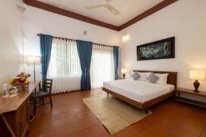 a bedroom with a bed and a table and a desk at Atoh's Maison in Siem Reap