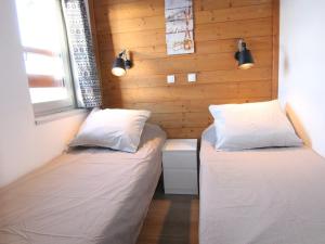 two beds in a small room with wooden walls at Appartement 3 pièces, 6 pers, 45m² - Couv.piscines, prox.pistes et écoles ski, parking, balcon, WiFi - FR-1-405-161 in LʼHuez