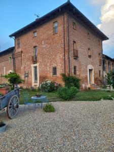 a large brick building with a bench in front of it at La Boheme in Villanova dʼAsti