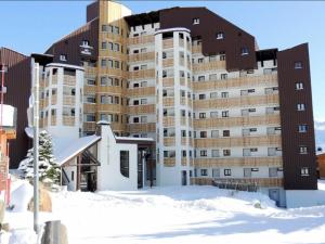ein großes Gebäude im Schnee vor einem Gebäude in der Unterkunft Appartement Huez, 2 pièces, 4 personnes - FR-1-405-155 in L'Alpe-d'Huez