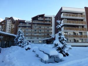 a building covered in snow with trees in front of it at Appartement Huez, 2 pièces, 6 personnes - FR-1-405-40 in L'Alpe-d'Huez