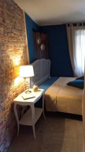 a bedroom with a bed and a table with a lamp at La Boheme in Villanova dʼAsti