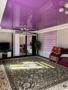 uma sala de estar com um sofá e tectos roxos em Bayzak guest house 