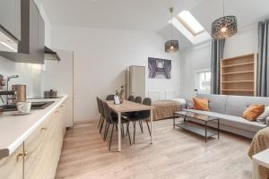 a kitchen and living room with a table and a couch at Kamienica Centrum Apartament 18 in Szczecin