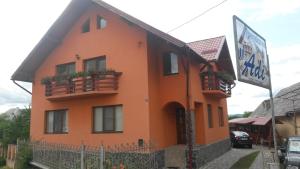an orange building with a sign in front of it at Pensiunea Adi Sapinta in Săpânța