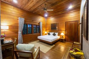 sypialnia z łóżkiem w drewnianym pokoju w obiekcie Atoh's Maison w Siem Reap