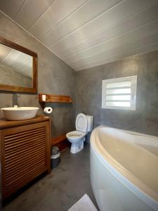 a bathroom with a tub and a sink and a toilet at La Caze Grande Anse in Petite Île +63 photos