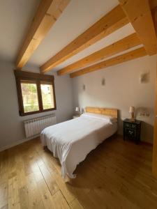Un dormitorio con una gran cama blanca y una ventana en Ático en la Antigua Casa de Correos, en Molina de Aragón