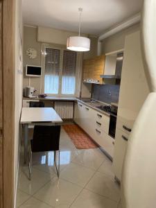uma cozinha com armários brancos e uma mesa em CASAMAGNOLIA em Cernusco sul Naviglio