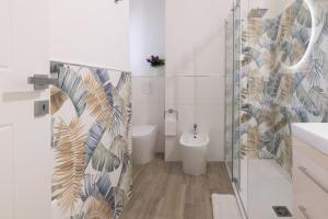 a bathroom with a toilet and a glass shower at Quarzo. Modern Rooms in Cagliari