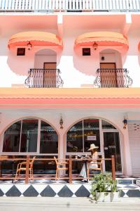 una mujer sentada en una mesa frente a un edificio en Sidewalk Boutique Hotel, en Ko Samed