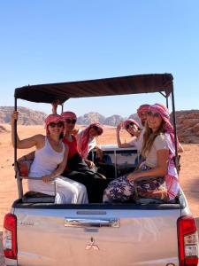 Un groupe de personnes à l'arrière d'un camion dans le désert dans l'établissement Bedouin Yoga & Trekking Camp Wadi Rum, à Wadi Rum